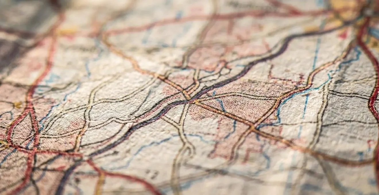 Overhead view of travel planning materials showing a map with marked anchor points and flexible route options