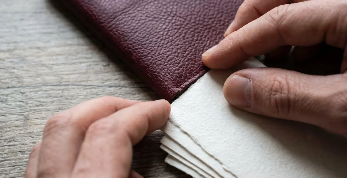 Close-up macro shot of hands organizing travel documents and passport on a clean surface
